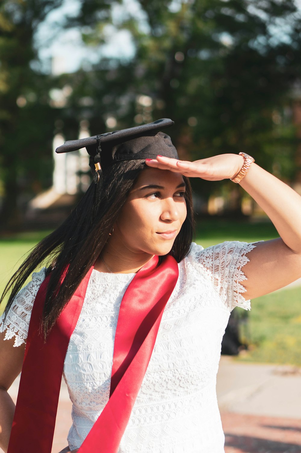 woman in white sleeveless dress wearing black mortar board