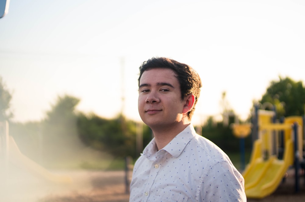 man in white and blue floral button up shirt standing during daytime