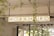 A rectangular sign with the words 'WORK HARD' is suspended from the ceiling. The background includes structural elements like pipes and beams, along with some greenery visible through windows.