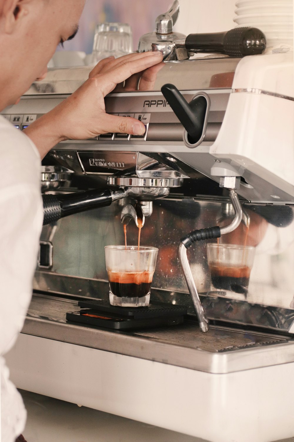 person holding black and silver espresso machine