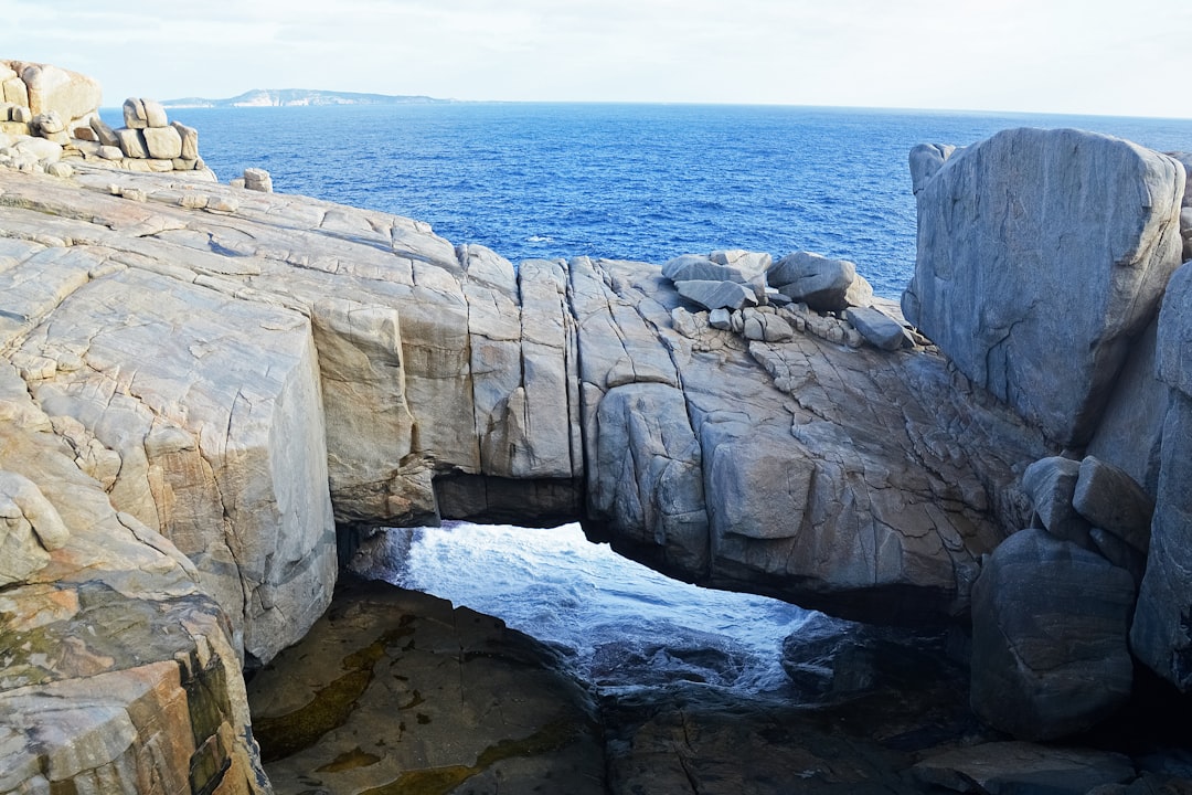 brown rock formation near body of water during daytime