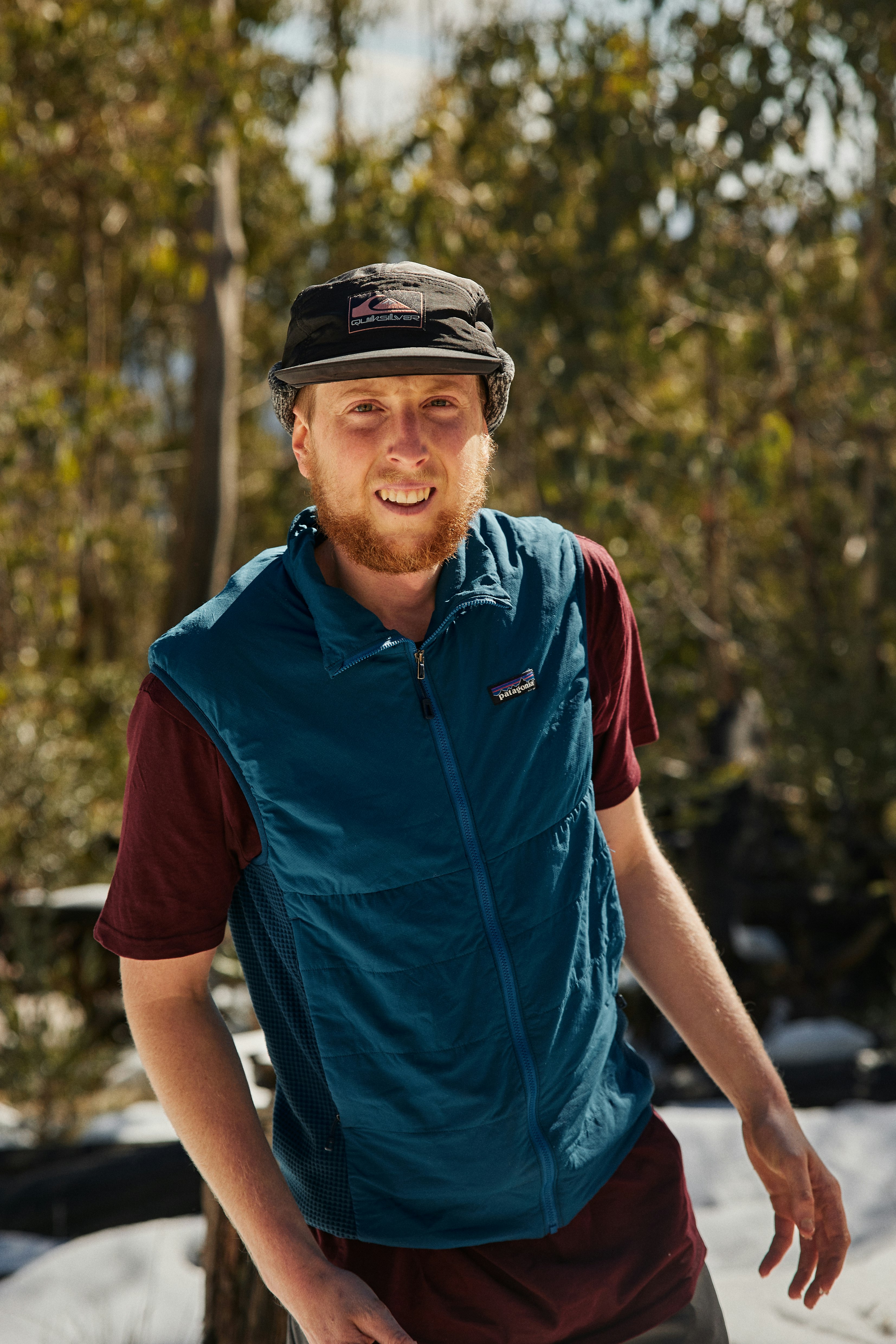 man in blue and red polo shirt wearing black and white cap
