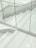 A staircase made of gray terrazzo and stainless steel lines, partially enclosed by transparent glass panels. The stair treads have several grooved lines running horizontally. The surrounding surfaces and the space appear clean and modern, with a minimalist design.