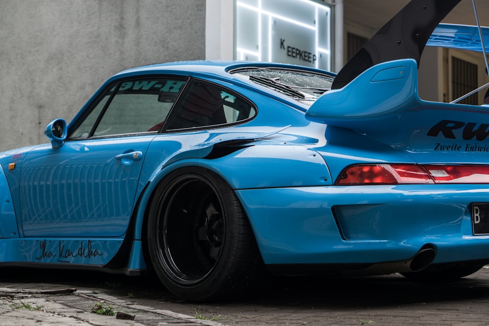 Porsche 911 bleue garée à côté d’une voiture noire