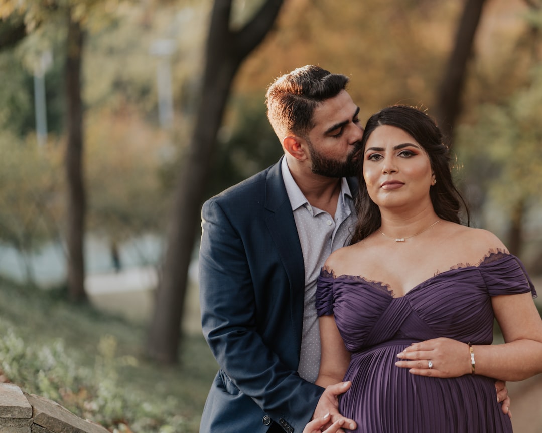 man in blue suit jacket hugging woman in blue and white striped dress