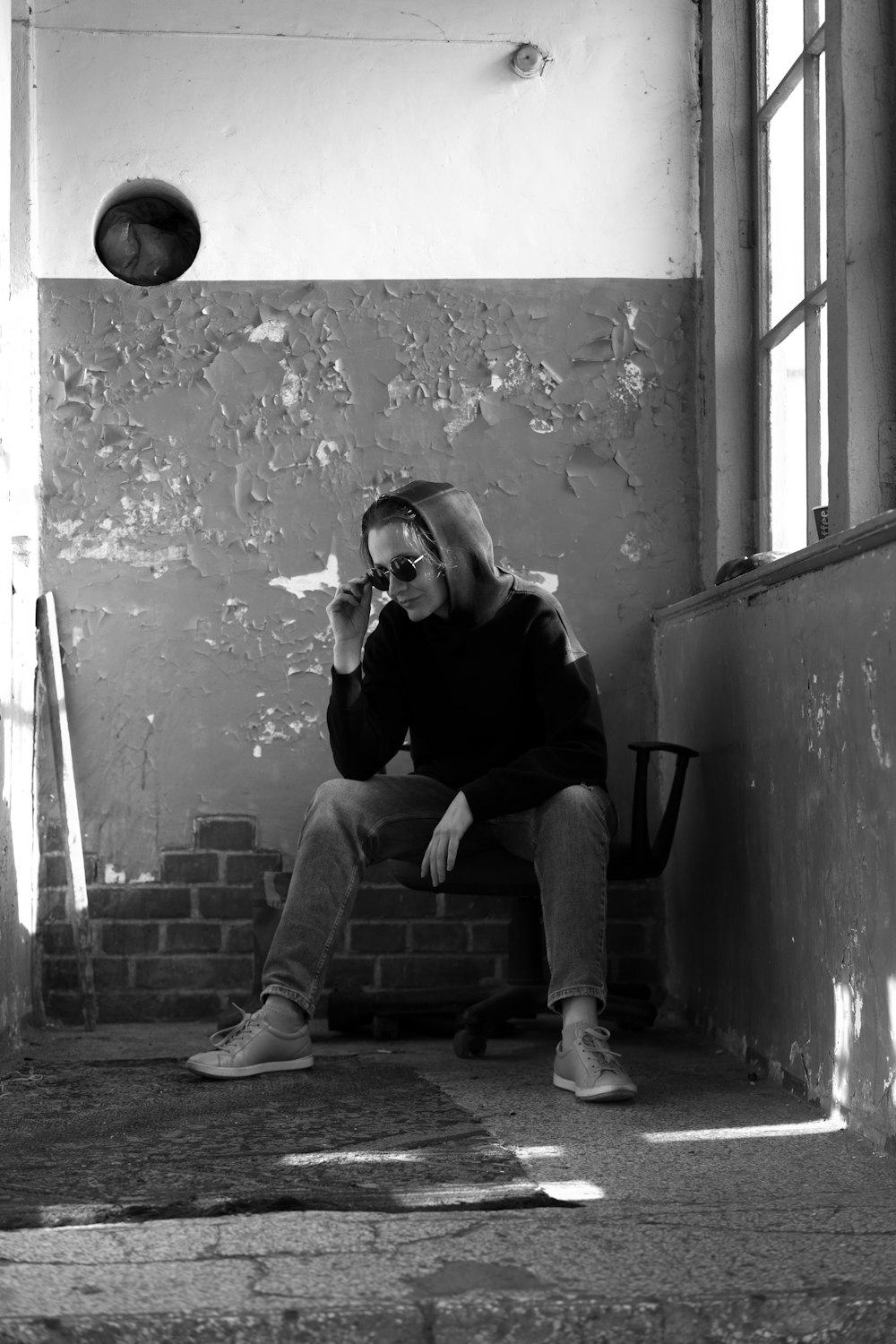 man in black jacket and pants sitting on concrete bench