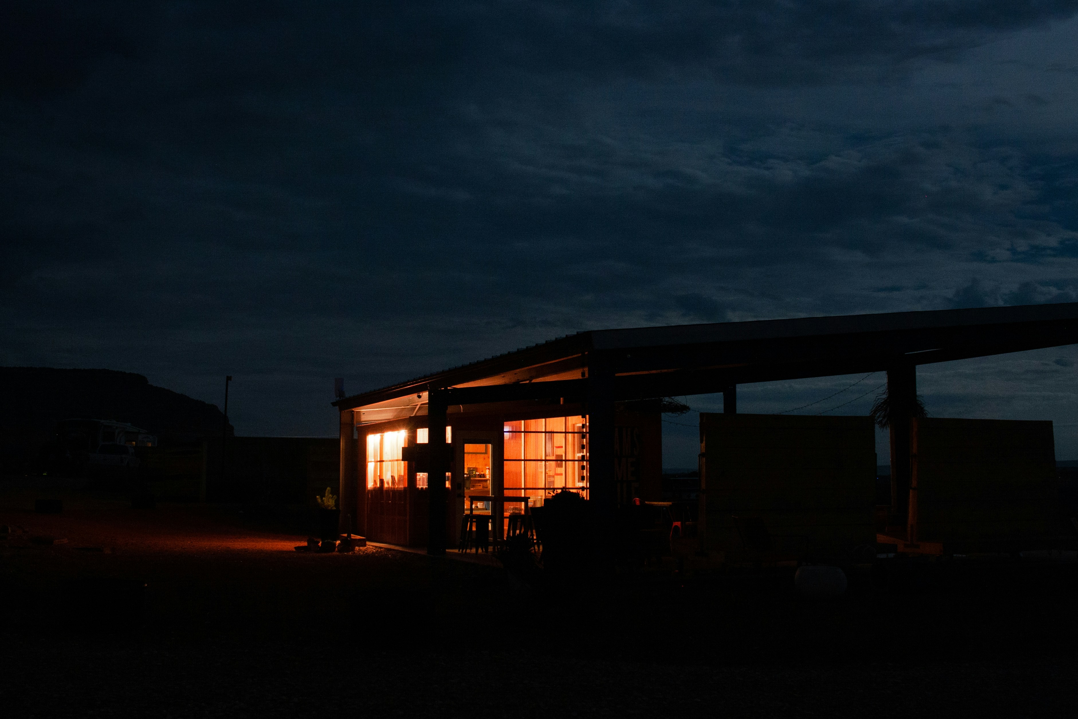 Row of Tesla Supercharger stalls at a charging station during sunset