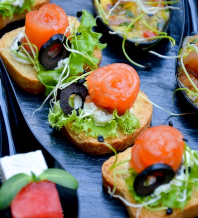 tomato and green leaf vegetable salad on brown wooden plate