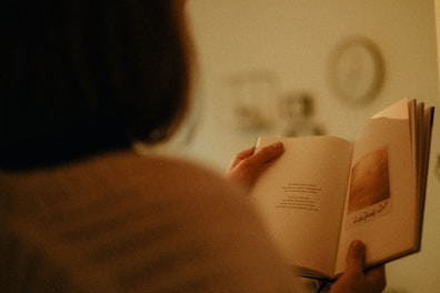 woman in white shirt holding book