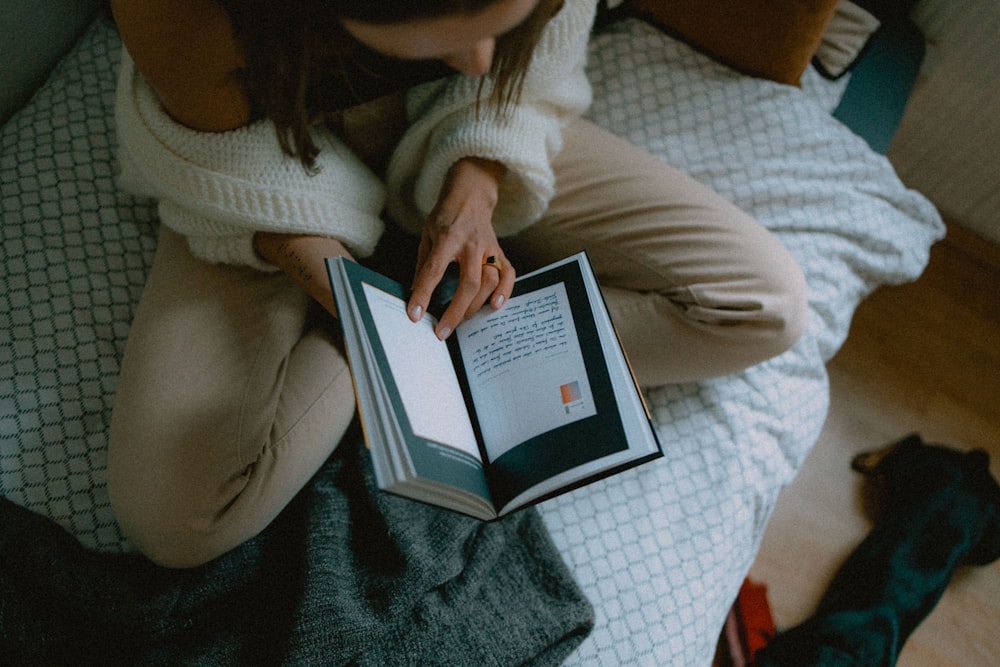 woman in white sweater holding white ipad