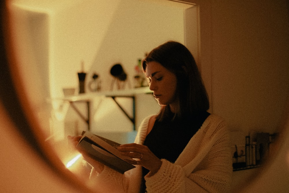 Frau im weißen Pullover mit Tablet-Computer