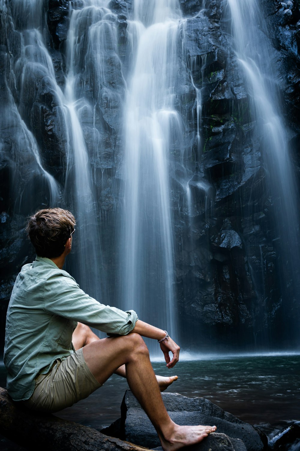 woman in green shirt sitting on water fountain