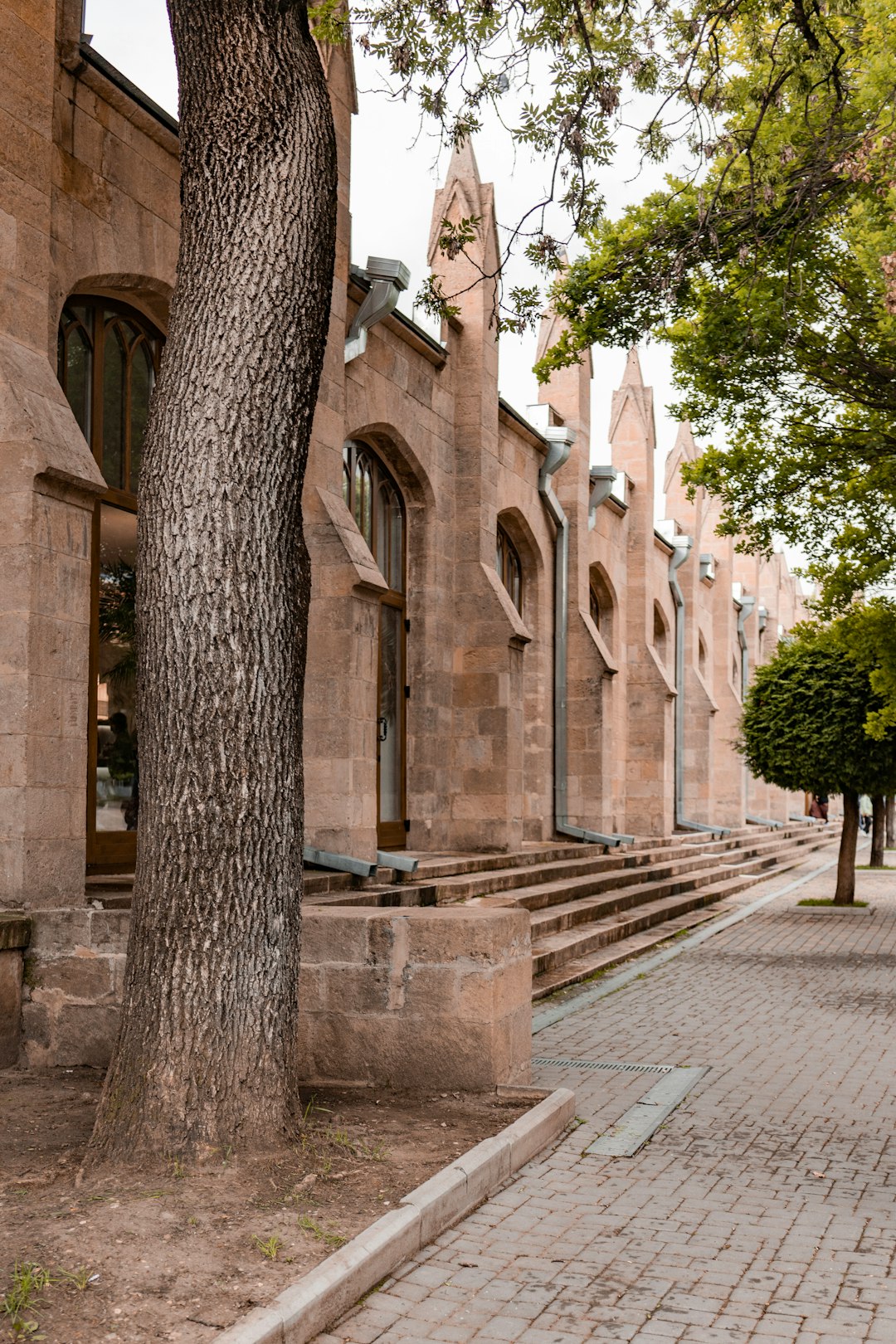 brown concrete building near green trees during daytime