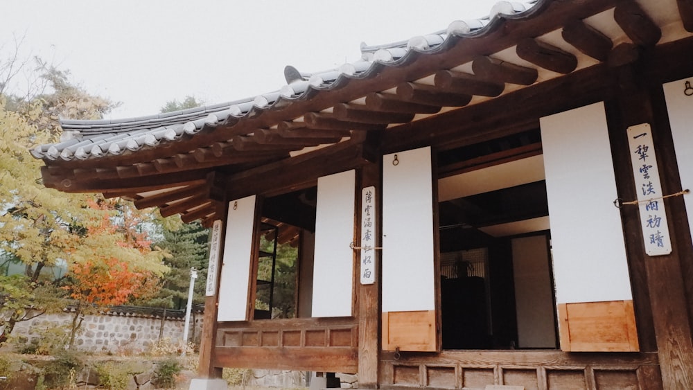 昼間は緑の木々が生い茂る茶色の木造家屋