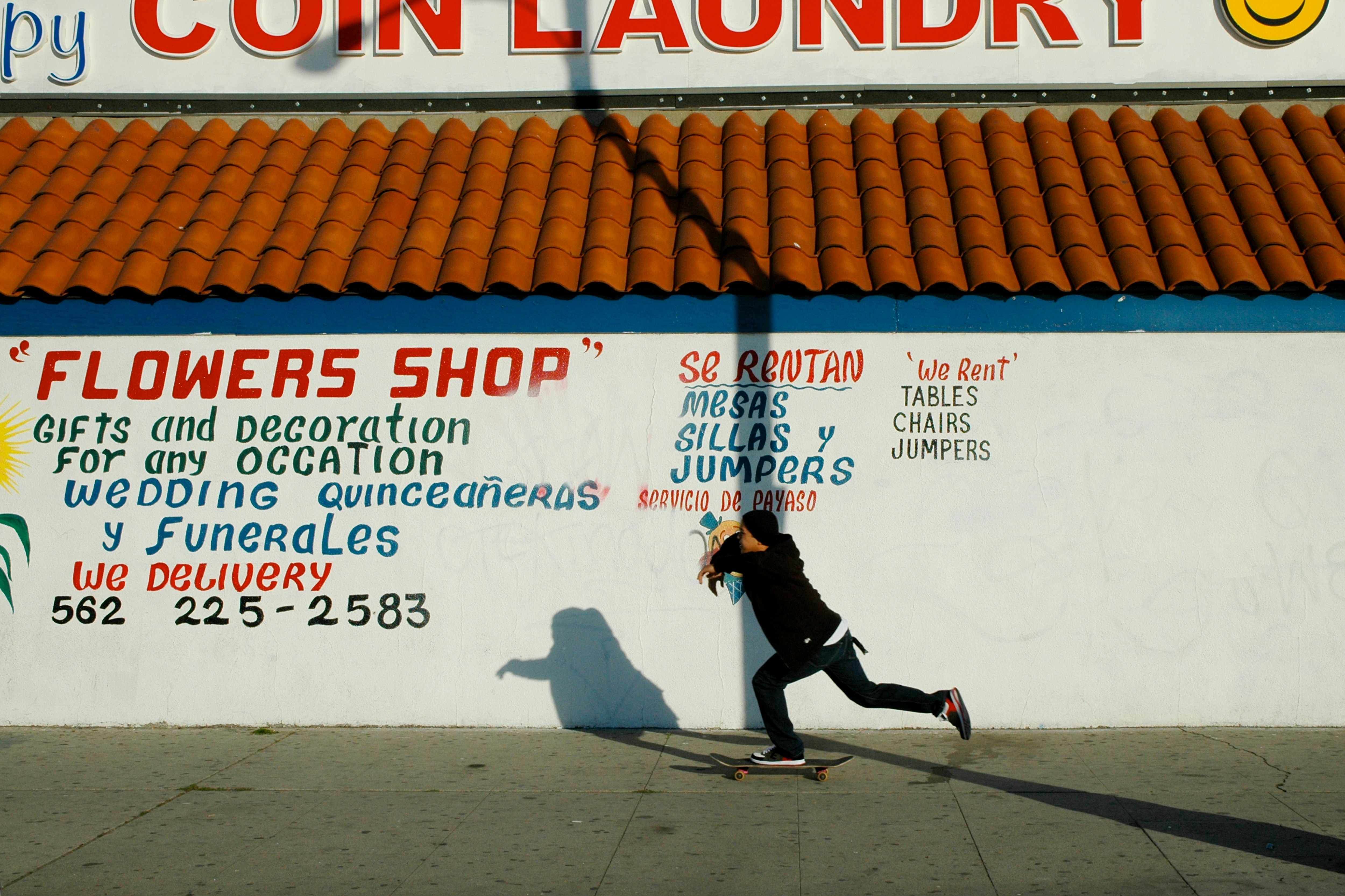 man in black jacket and black pants walking on sidewalk during daytime