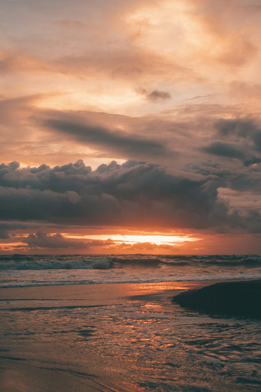 body of water under cloudy sky during sunset