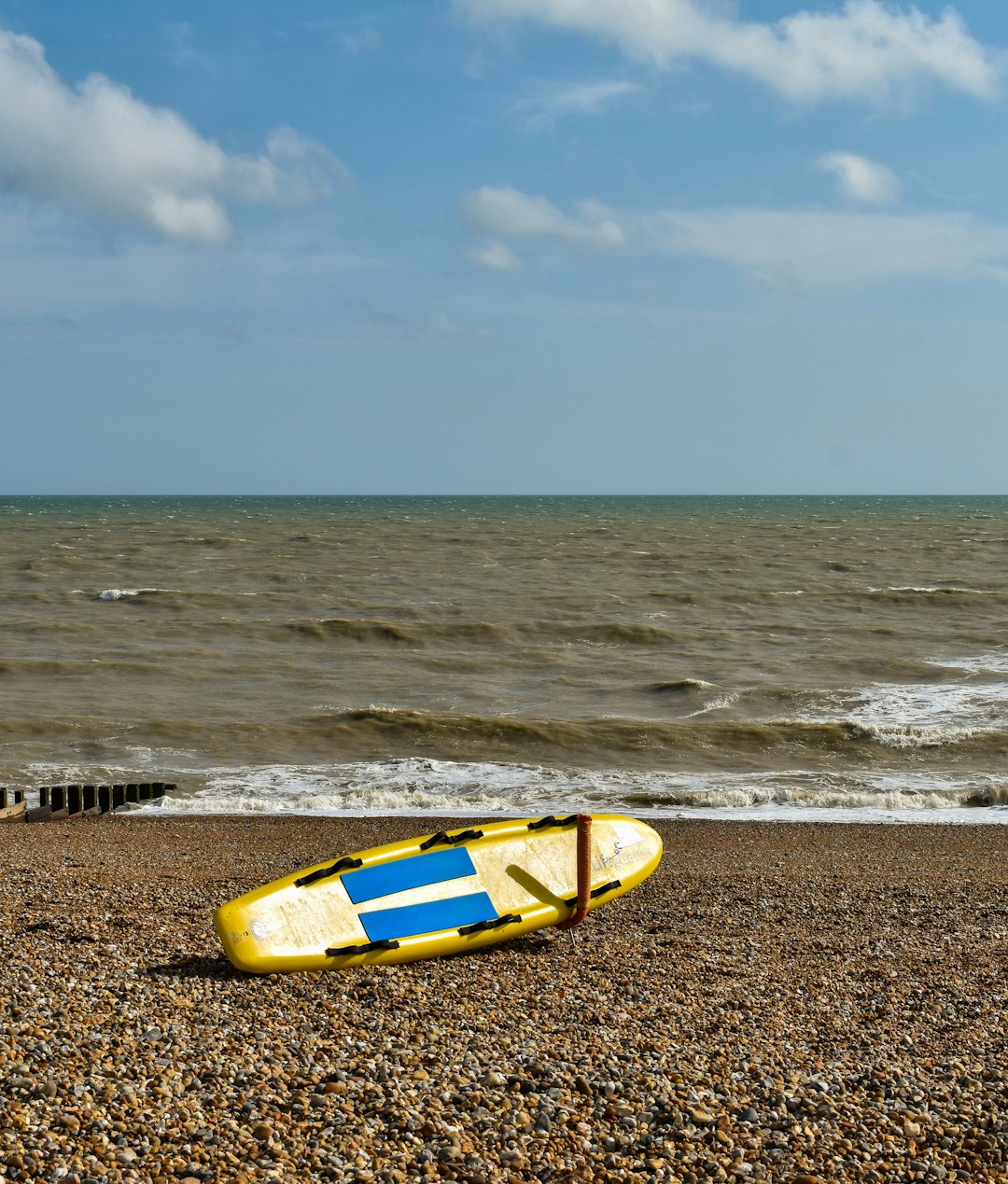 yellow and blue kayak on beach shore during daytime