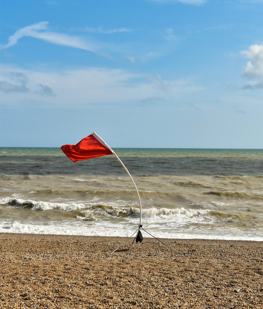 red flag on brown sand beach during daytime