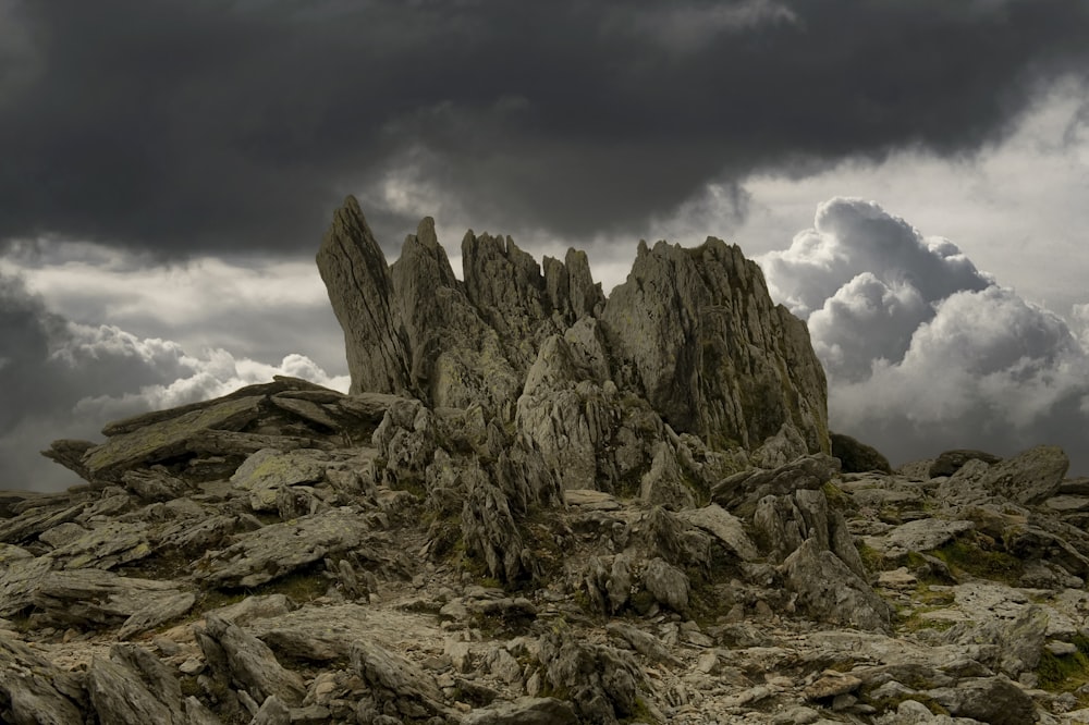 gray rocky mountain under cloudy sky during daytime