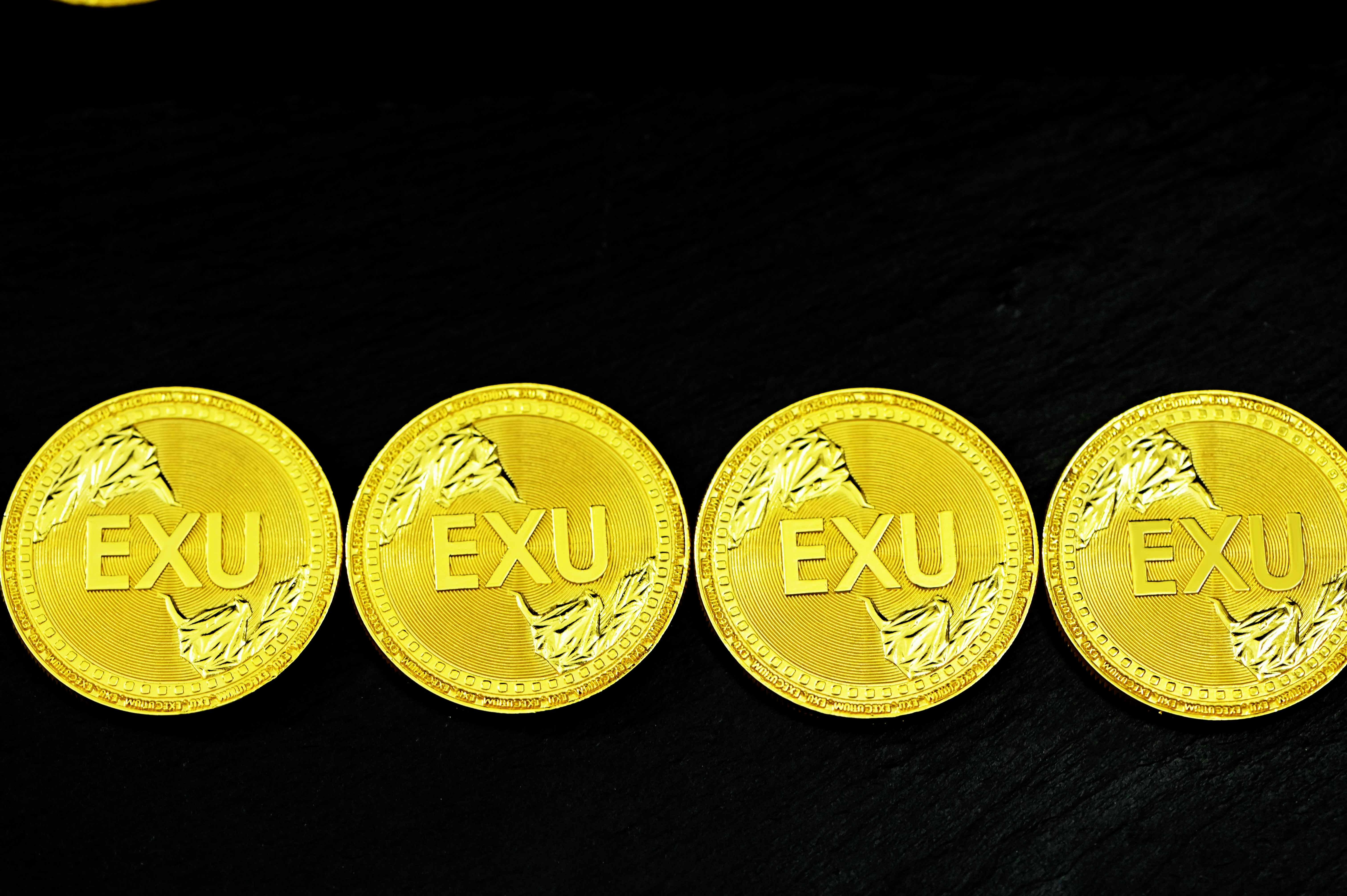 2 gold round coins on black surface