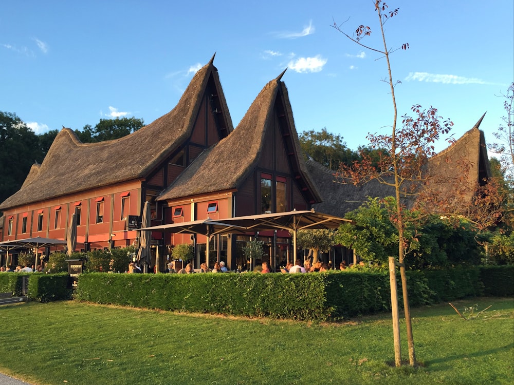 maison brune et noire près du champ d’herbe verte sous le ciel bleu pendant la journée