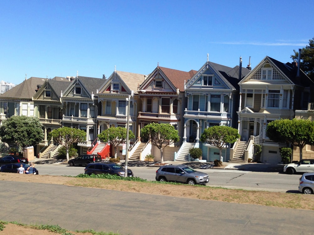 cars parked in front of white and brown concrete building during daytime