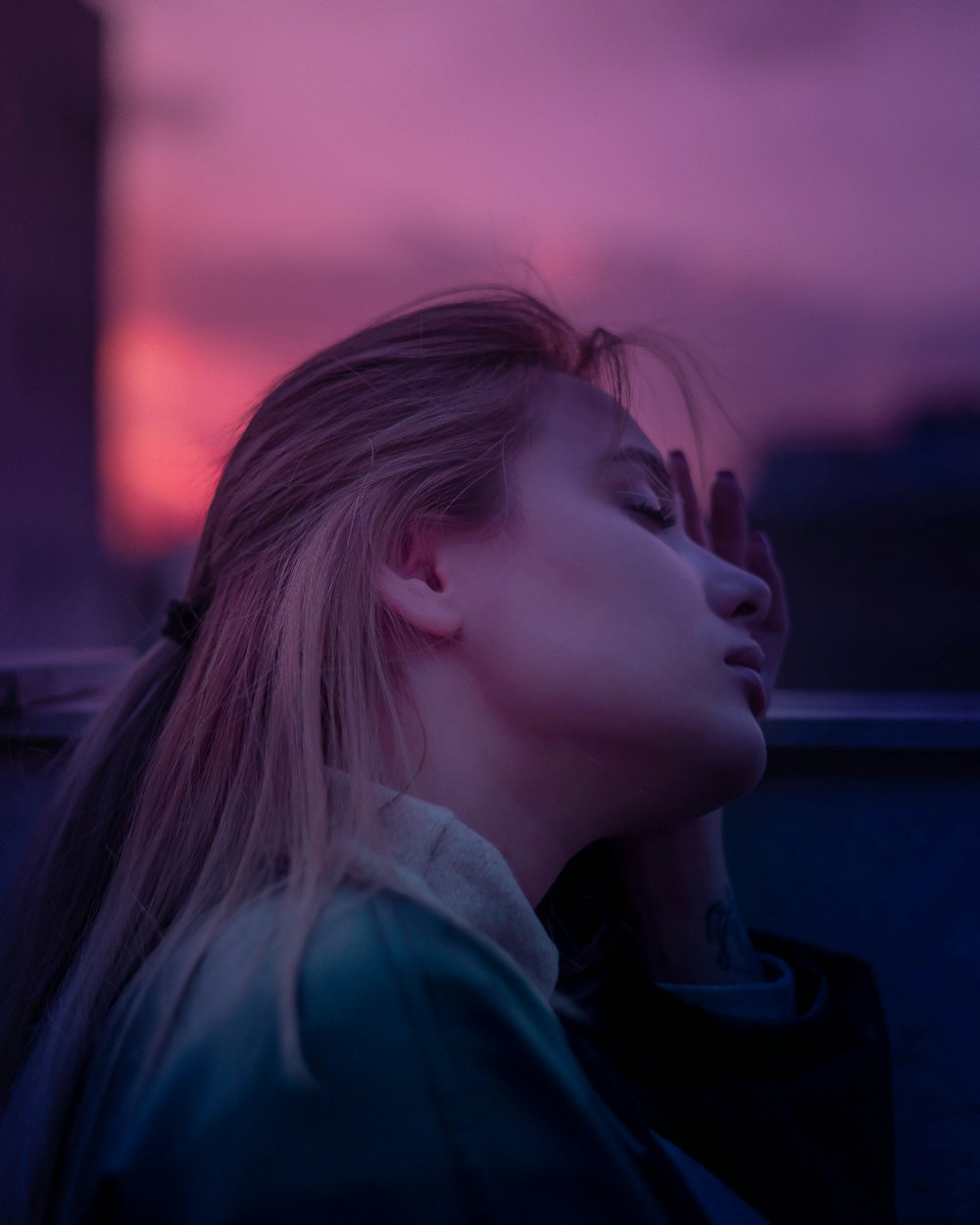 woman in blue hoodie looking at the window