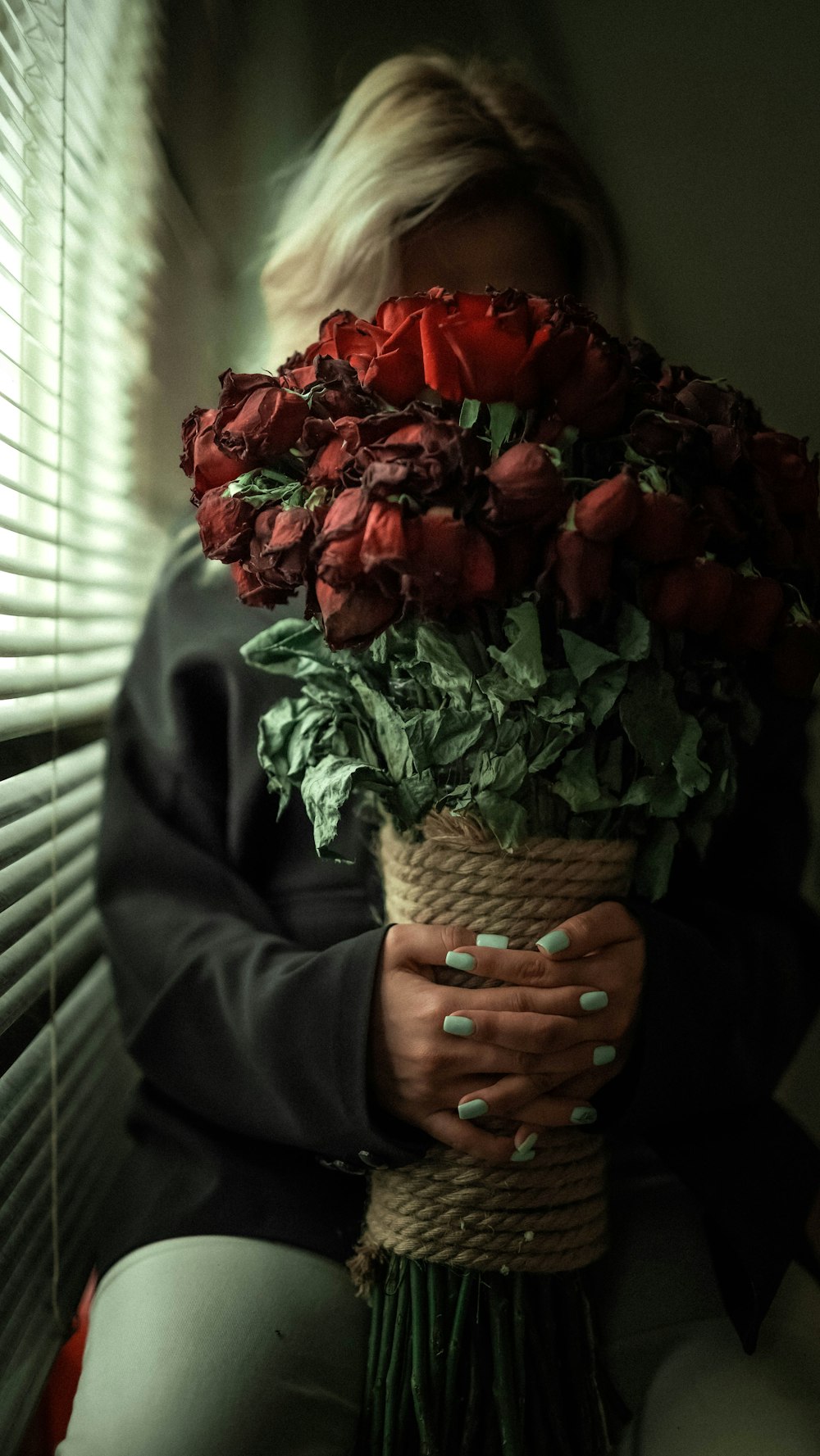 person holding red roses bouquet