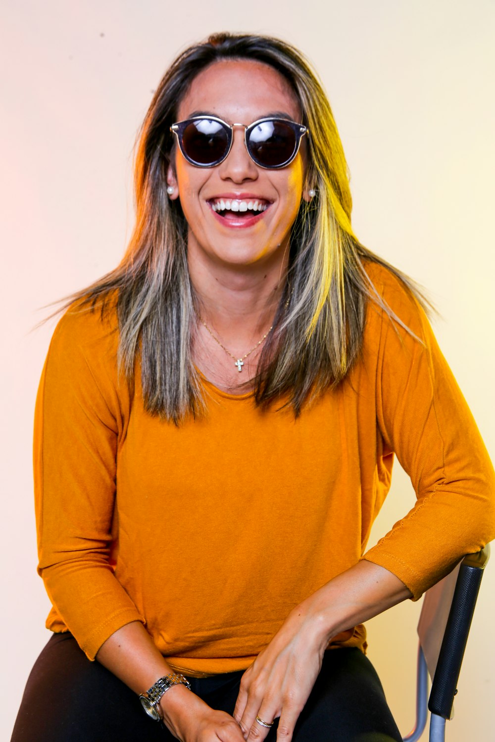 woman in orange crew neck long sleeve shirt wearing black sunglasses