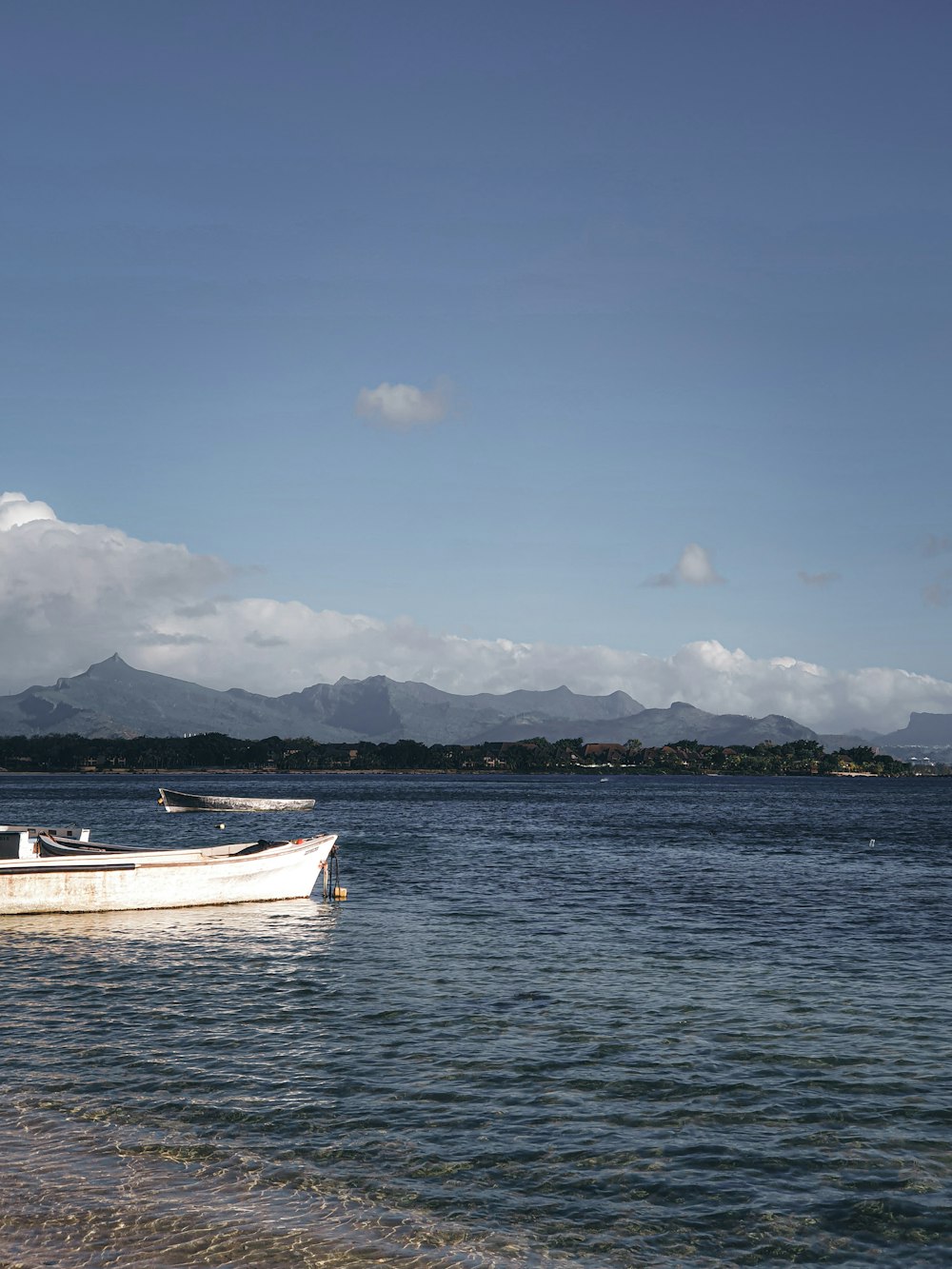 white boat on sea under blue sky during daytime