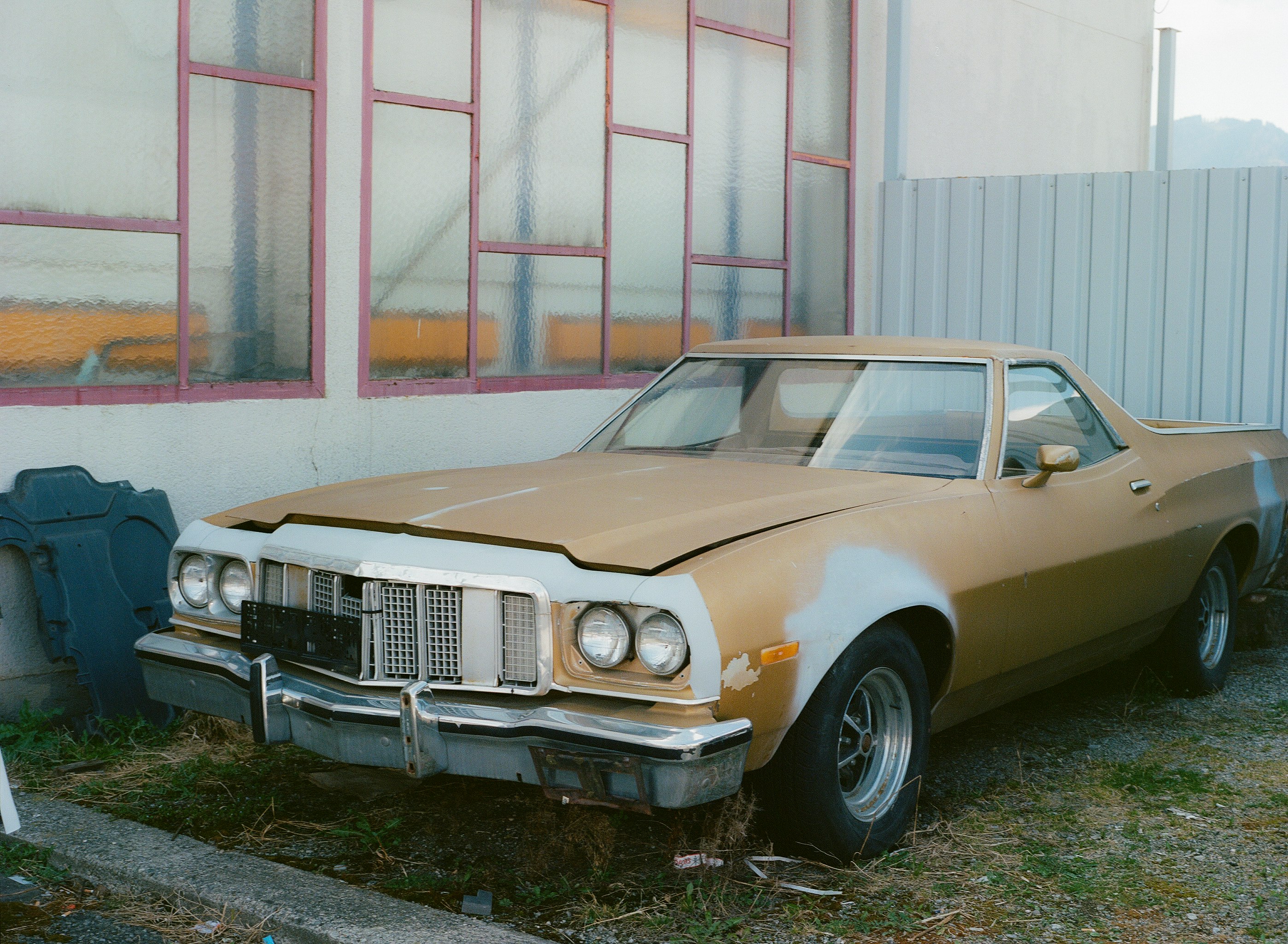 white classic car parked near white and brown building