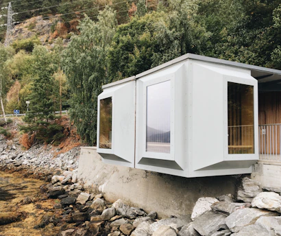white wooden house on rocky ground