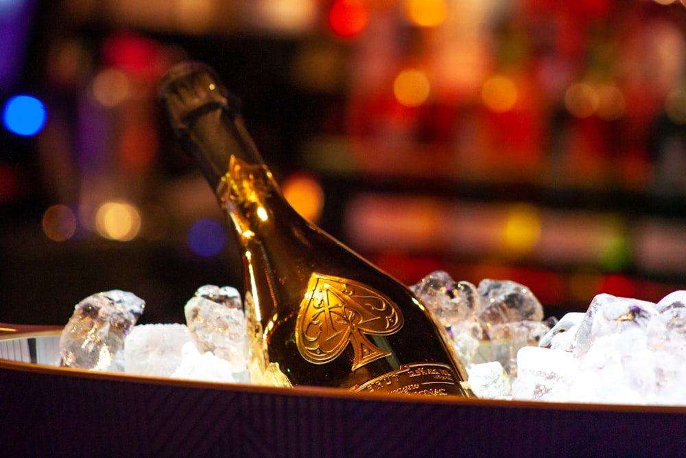 gold and black bottle on brown wooden shelf