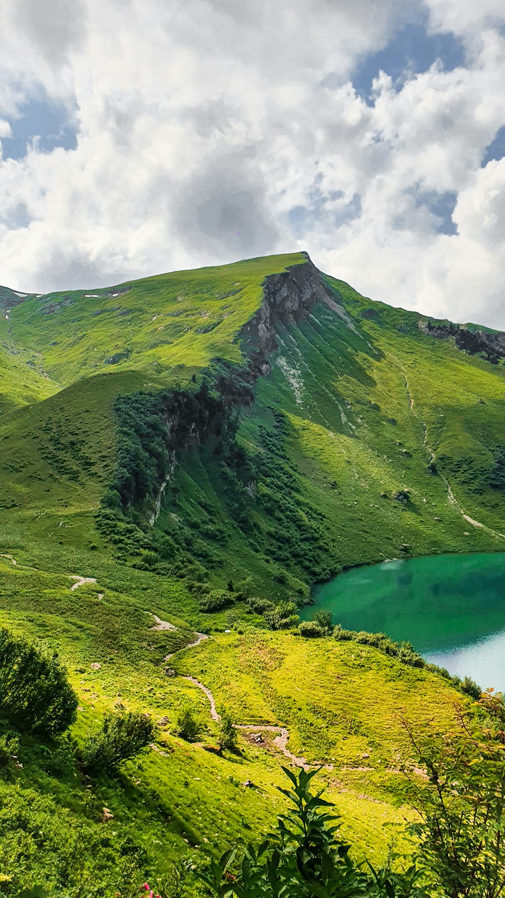 green mountain beside body of water during daytime