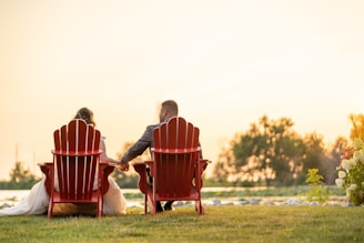 A couple relaxing on a wooden deck overlooking the calm waters of Cherai lake at sunset.