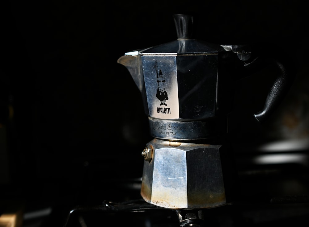 stainless steel coffee pot on black table