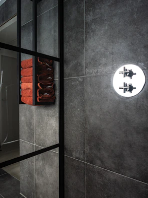 Spacious bathroom remodel featuring dark charcoal tiles and futuristic fixtures.