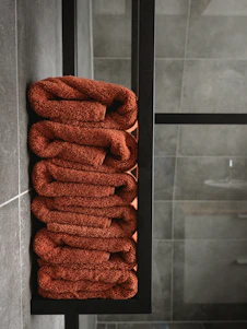 brown towel on white ceramic wall tiles