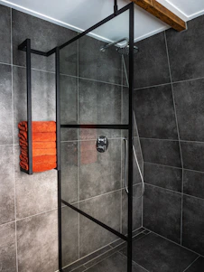 A bright, modern bathroom with a walk-in shower featuring grab bars and a foldable seat, designed for senior safety.