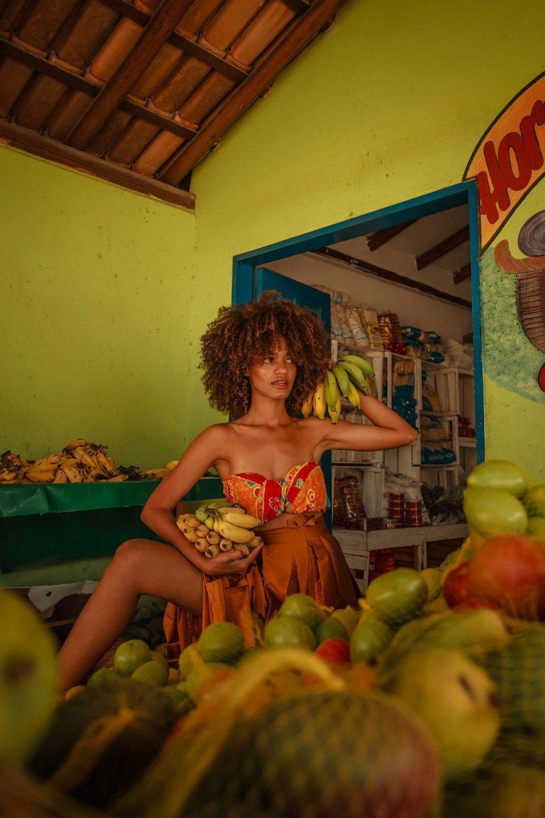 woman in red and white floral spaghetti strap top holding green apple fruit