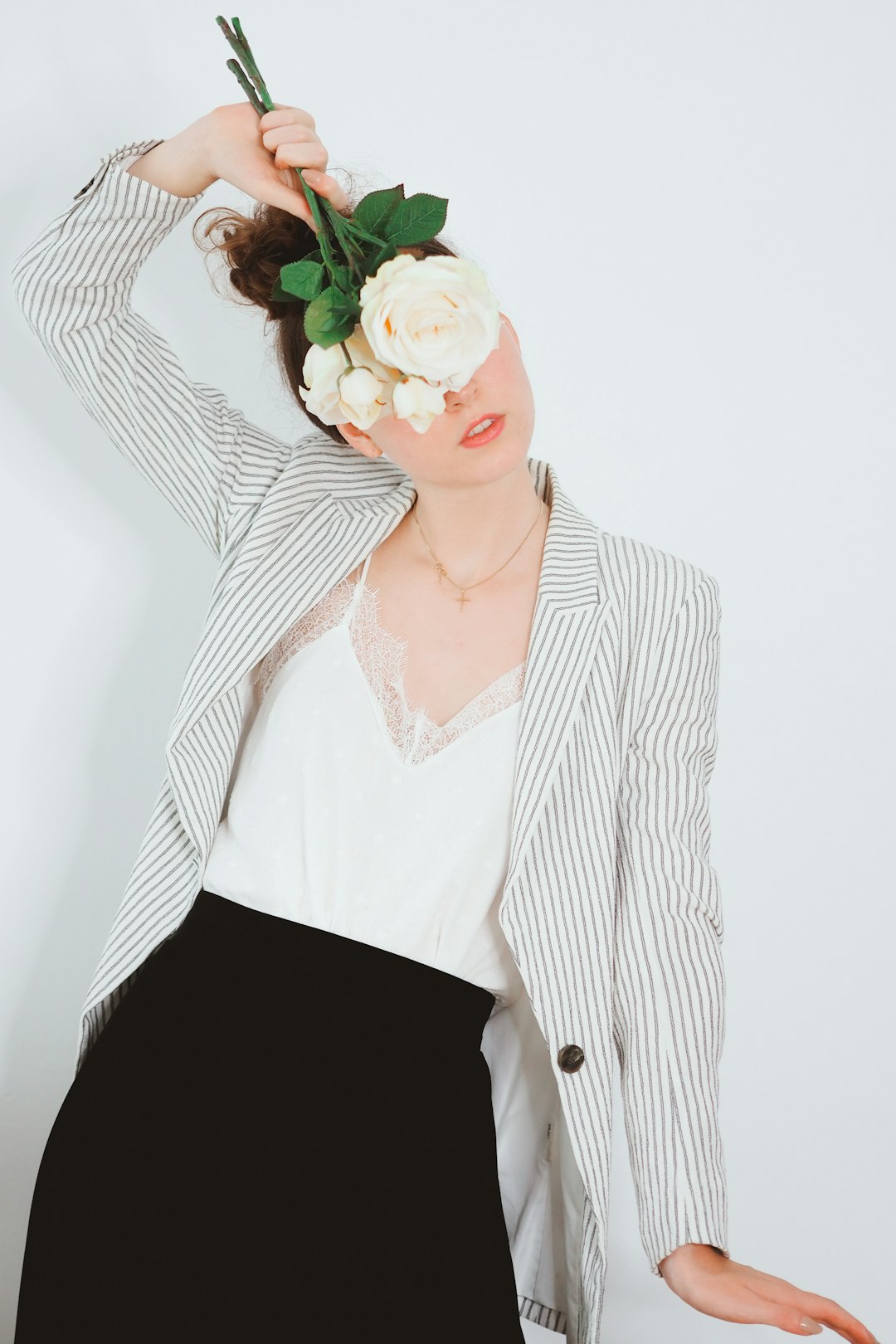 woman in white and black pinstripe blazer with black skirt and white and red rose on with on with on