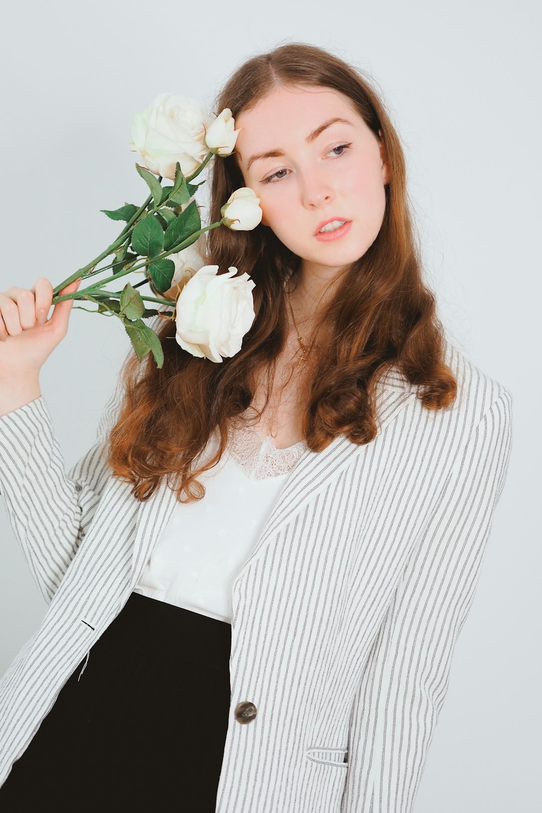 woman in white and black striped long sleeve shirt holding white rose