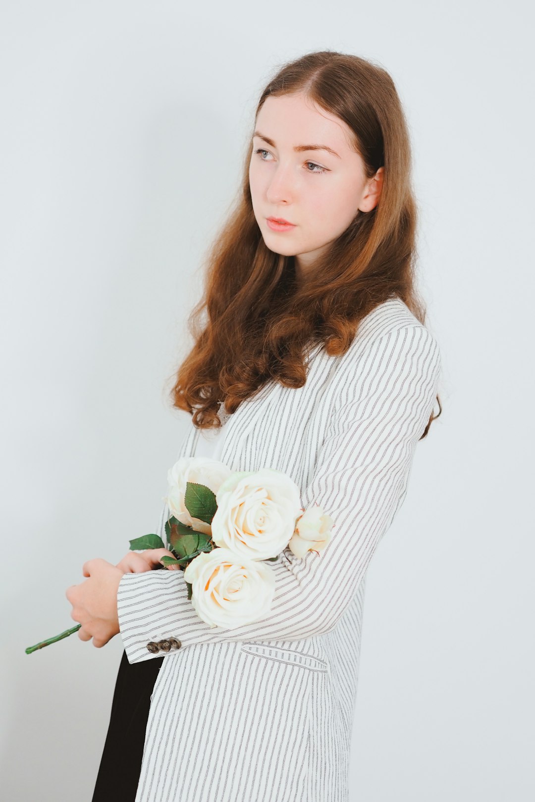 woman in white long sleeve shirt holding white and green flower bouquet