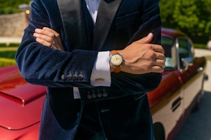 man in black suit jacket wearing gold round analog watch