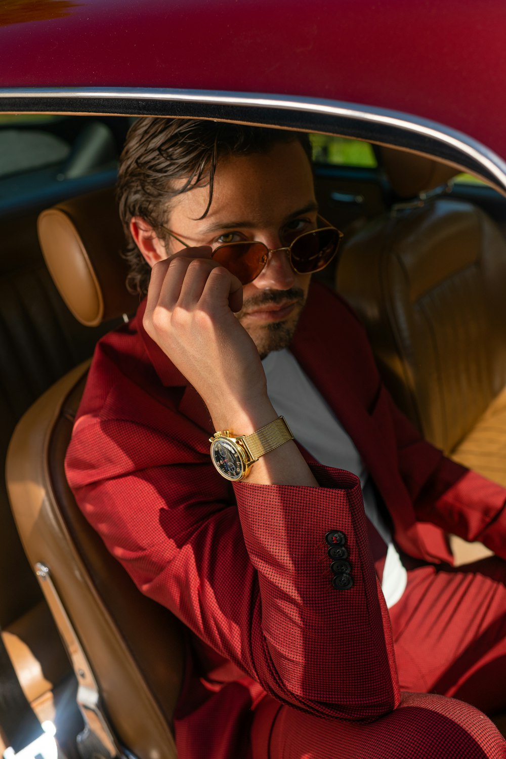 man in red jacket wearing black sunglasses