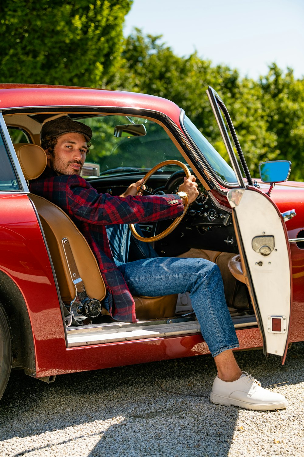 man in red and black plaid dress shirt and blue denim jeans sitting on red and