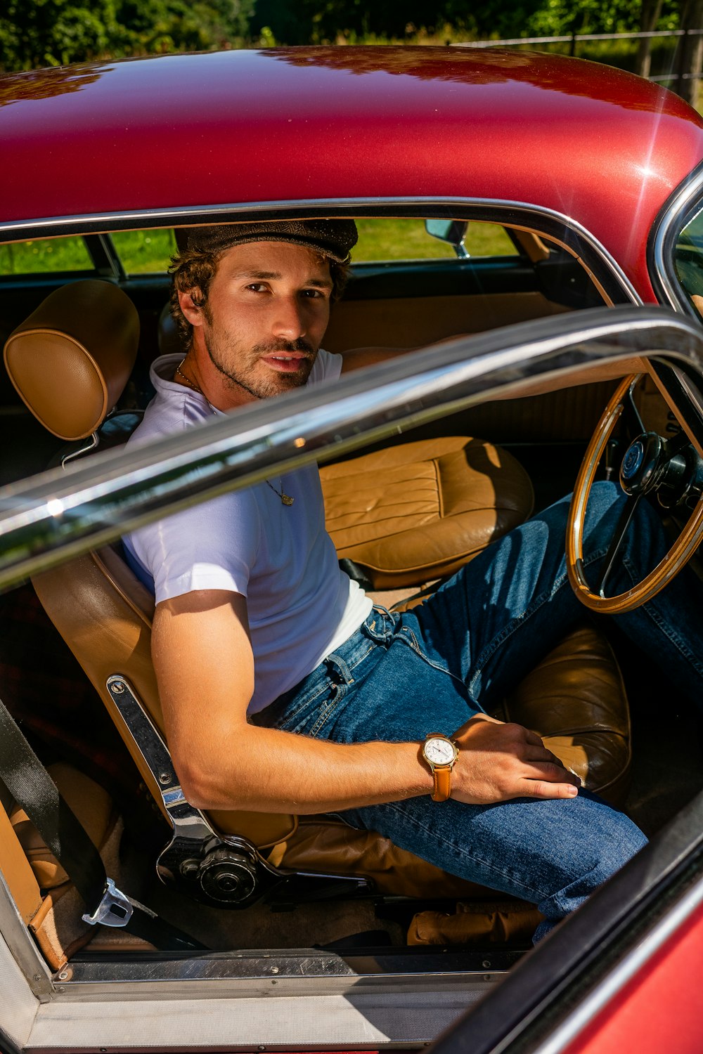 man in white t-shirt and blue denim jeans sitting on car seat