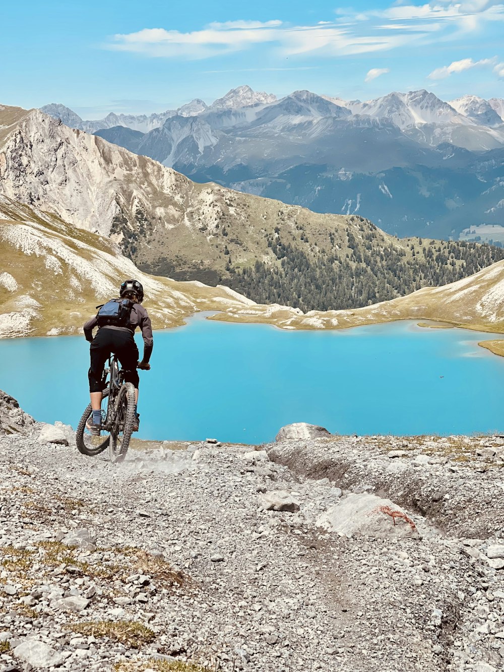 man in black jacket riding bicycle on mountain during daytime
