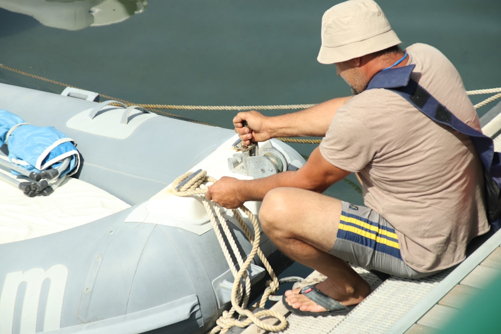 man in brown t-shirt sitting on white boat during daytime