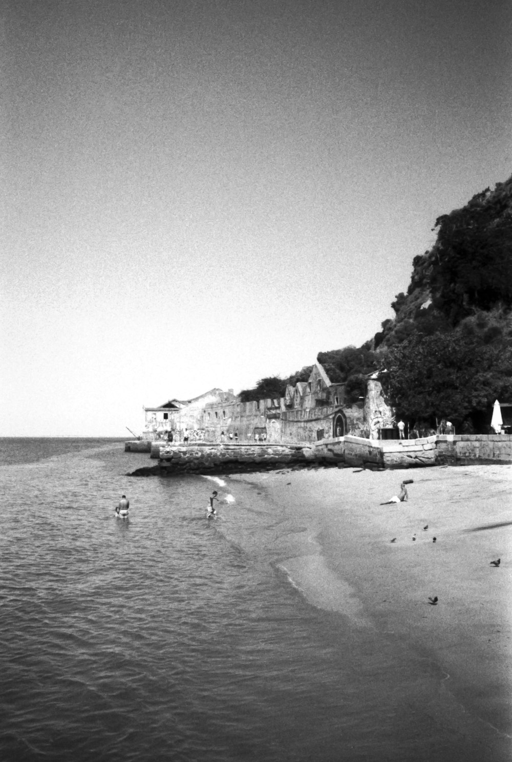 grayscale photo of people on beach